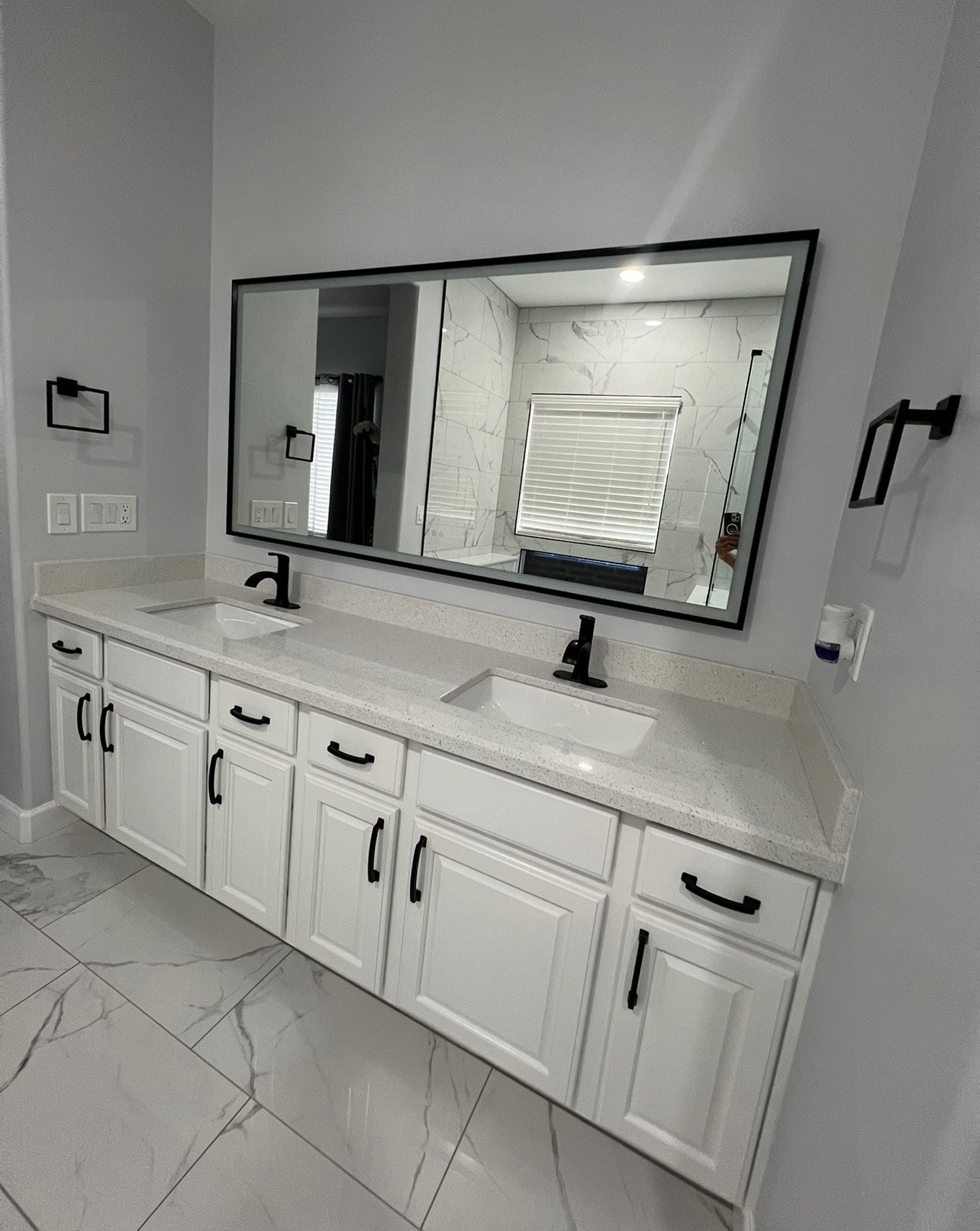 Bathroom double vanity with marble tile and black fixtures