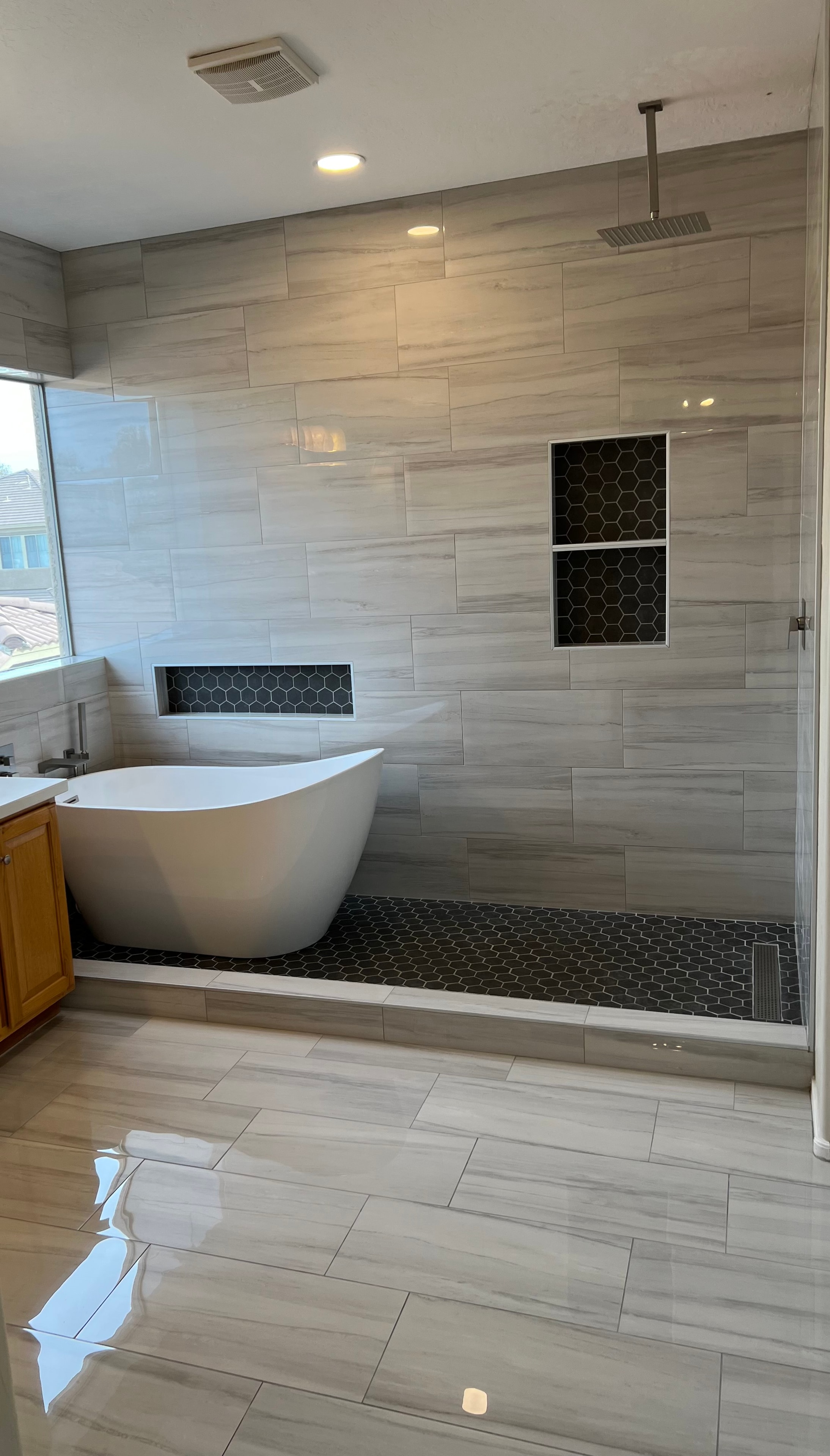 Luxury bathroom remodel with freestanding soaking tub, large format tile, and walk-in shower