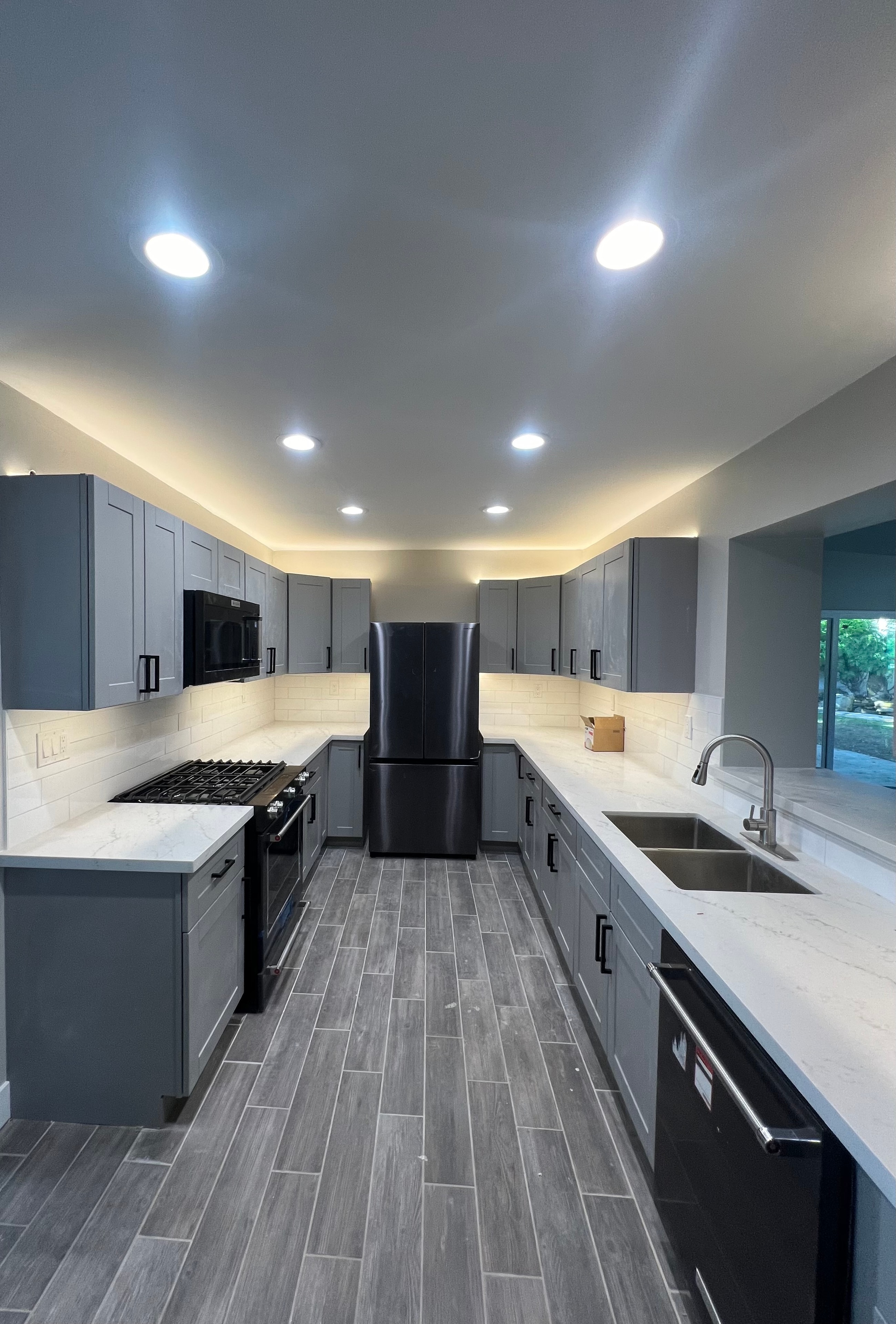 Full kitchen remodel with gray shaker cabinets, quartz countertops, and LED cove lighting
