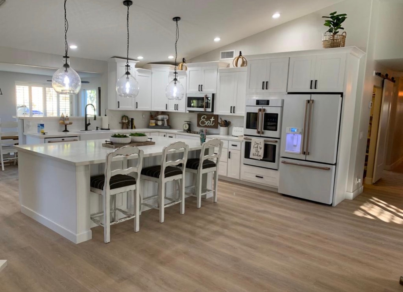 Kitchen remodel with white cabinetry, island, and hardwood flooring